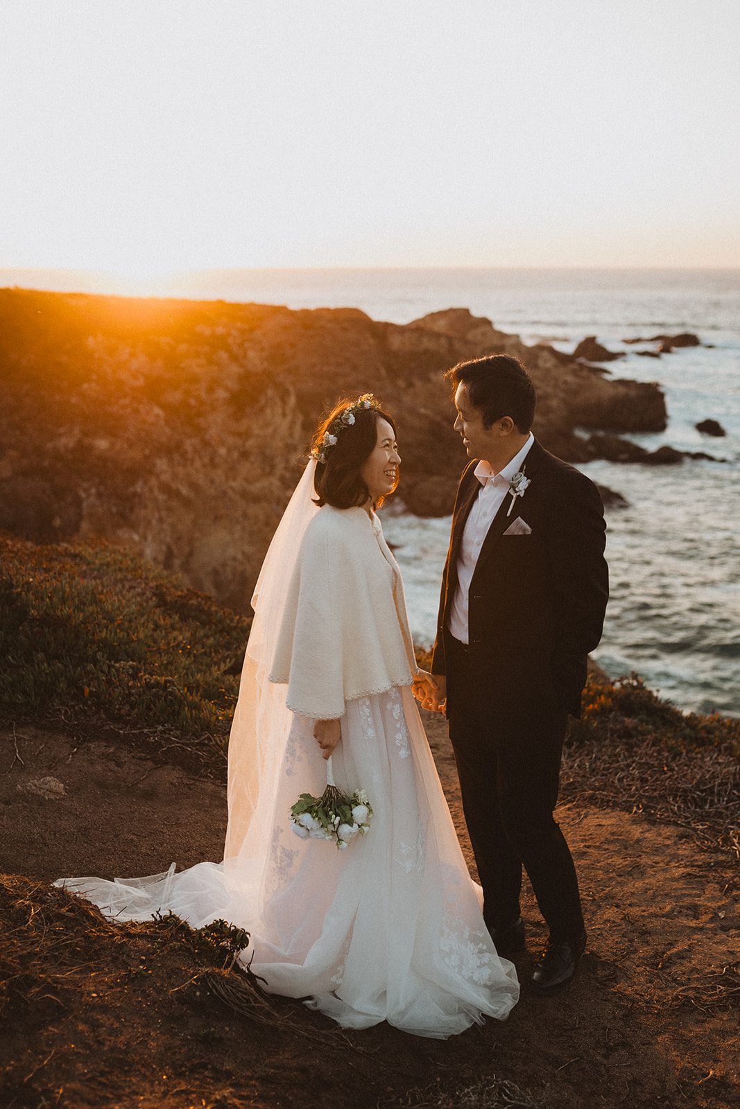 Bride and groom share a glance during sunset overlooking Garrapata State Park for their elopement.